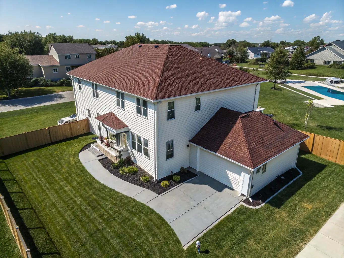 Aerial shot of a residential property with a large backyard, capturing the home’s surroundings and neighborhood context. The drone footage should provide a comprehensive view of the property and its location, emphasizing its unique features.